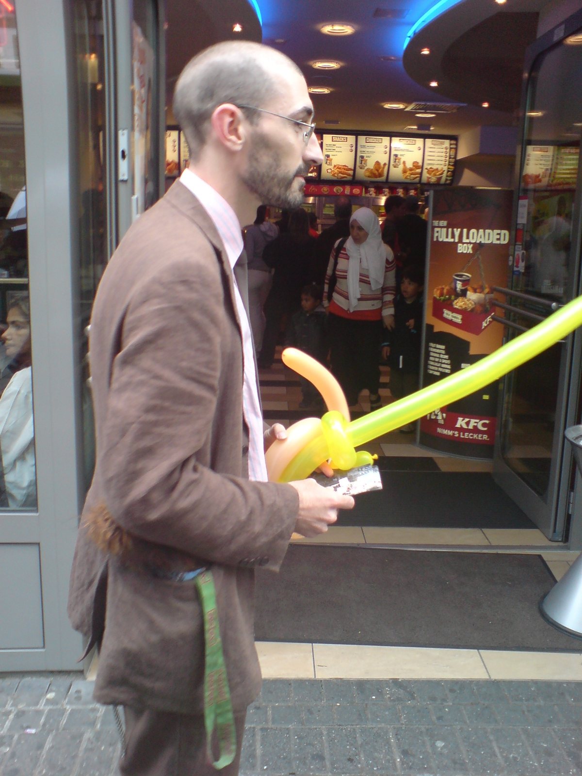 A team member in a suit with a balloon sword on the shopping street