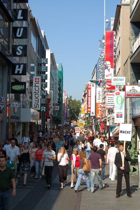 macht — the Cologne shopping street with the word 'macht' (power) overlaid