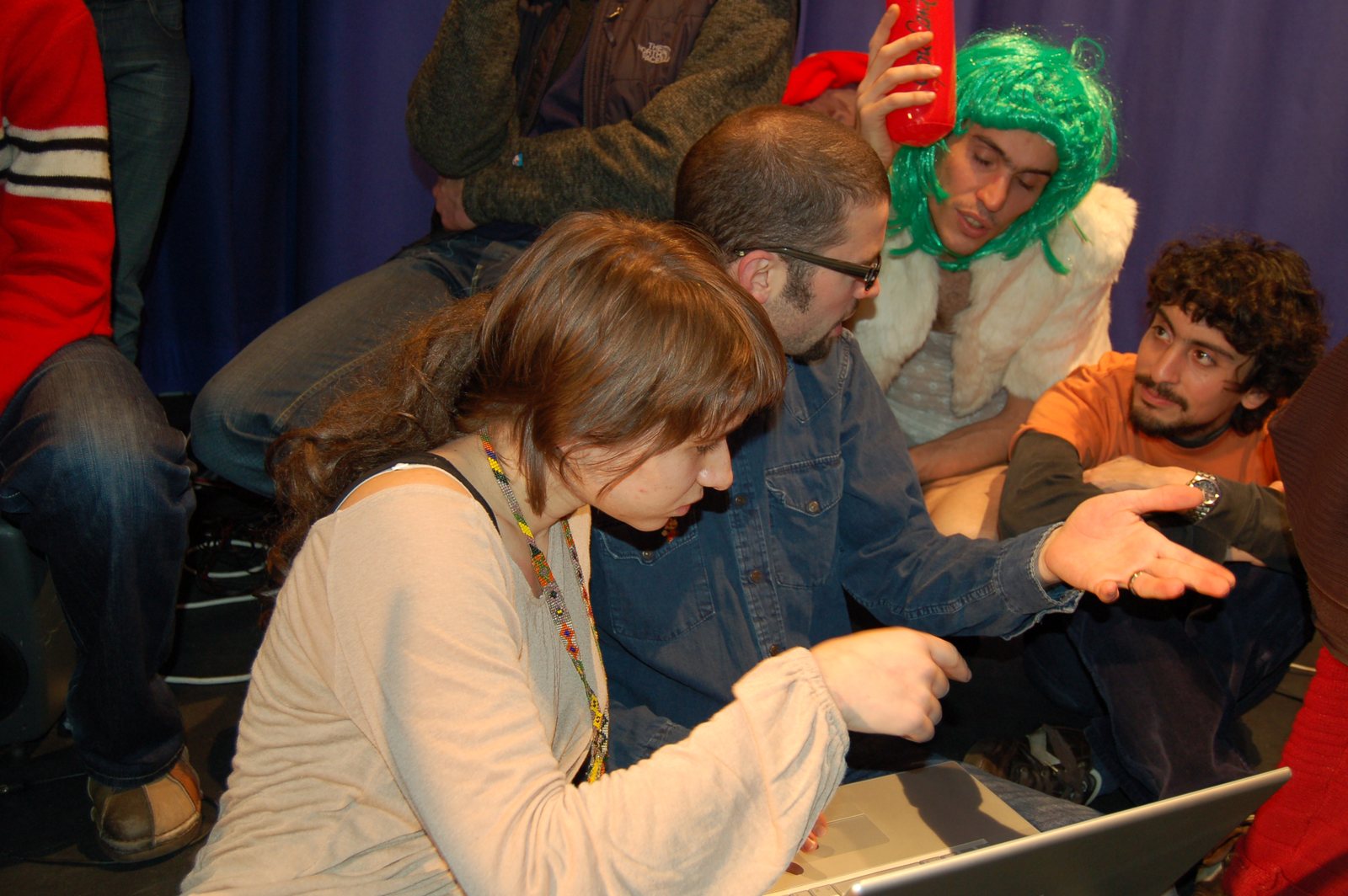 ge:schütz in a green wig with the team at a laptop during the happening